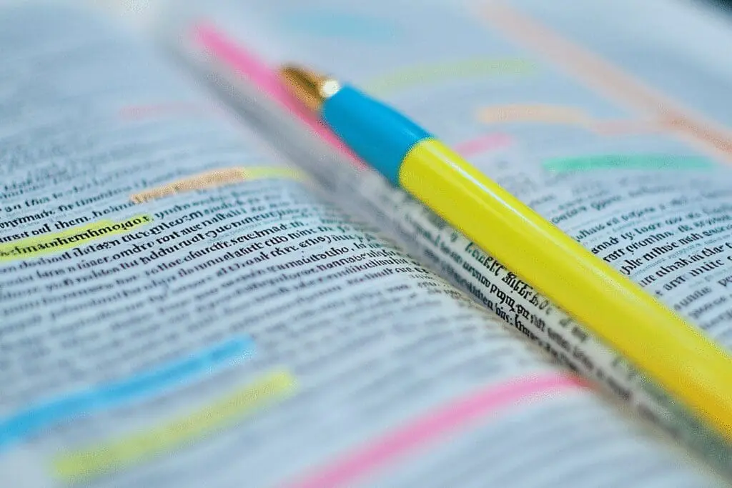 A close-up of a Bible page with neat, multi-colored highlighting, showing a color-coding system for study