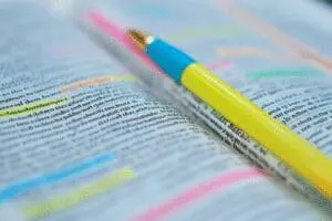 A close-up of a Bible page with neat, multi-colored highlighting, showing a color-coding system for study