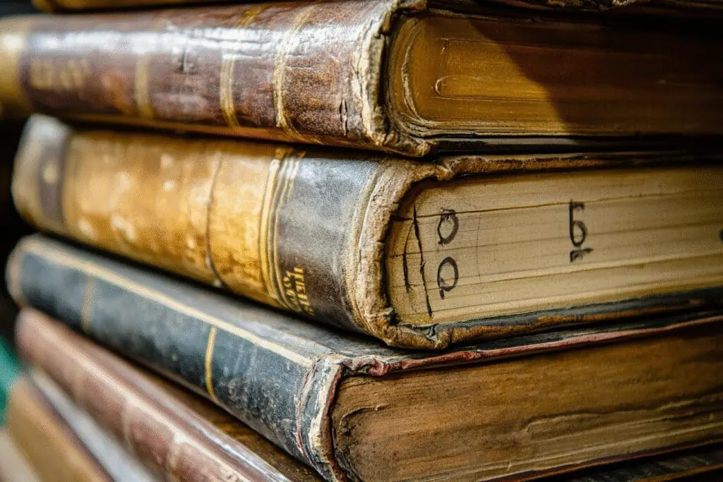 A stack of Bible books with the top five visibly thicker and marked with numbers, representing the longest books