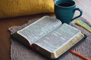 An open Bible lies next to a reading plan chart, showing a clear, organized order for reading