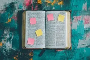 An open Bible seen from above, with small sticky notes marking verses to provide helpful tips for a good place to start