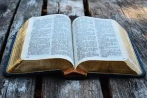 An open Book of Mormon separate from a closed Christian Bible, symbolizing why the Book of Nephi is not included