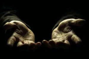 A pair of greedy hands reaching for something illustrating the answer to the question what is covetousness in the Bible