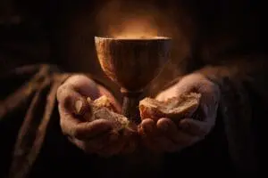 Hands holding a glowing chalice and bread symbolizing what is the New Covenant in the Bible