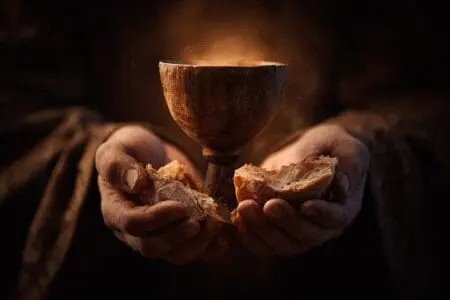 Hands holding a glowing chalice and bread symbolizing what is the New Covenant in the Bible