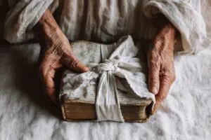 Hands wrapping an old Bible in a cloth demonstrating how to dispose of a Bible respectfully
