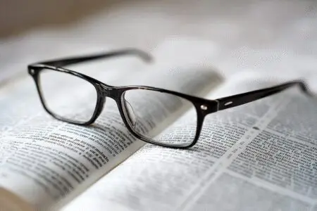 Reading glasses on an open Bible with large clear text illustrating what is the easiest Bible to read
