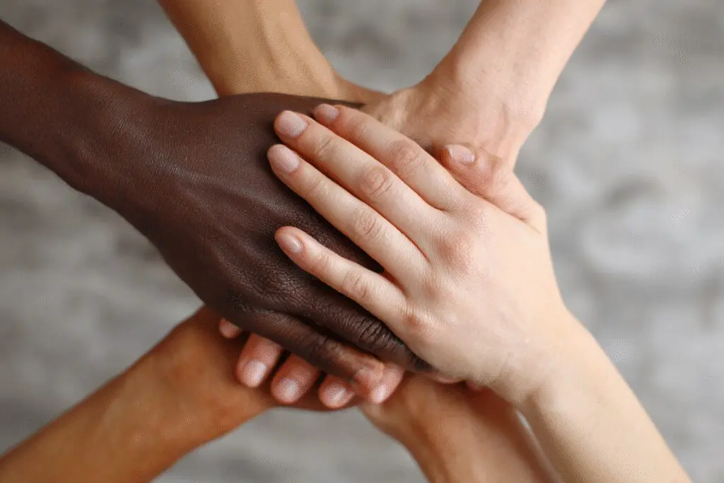 Hands of different skin colors clasped in unity illustrating what the Bible says about racism