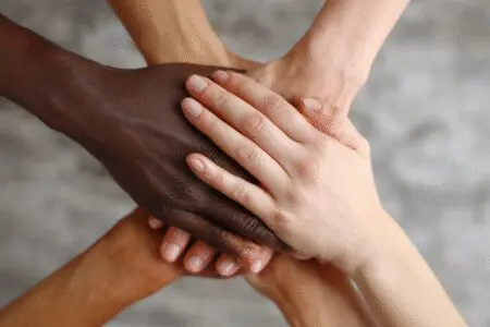 Hands of different skin colors clasped in unity illustrating what the Bible says about racism