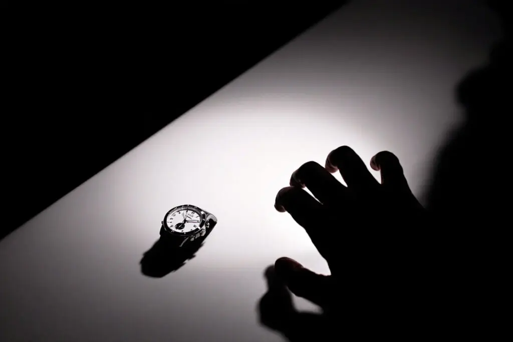 a shadowed hand reaching for a desired object in dim light representing the temptation and act of theft relating to what the bible says about theft