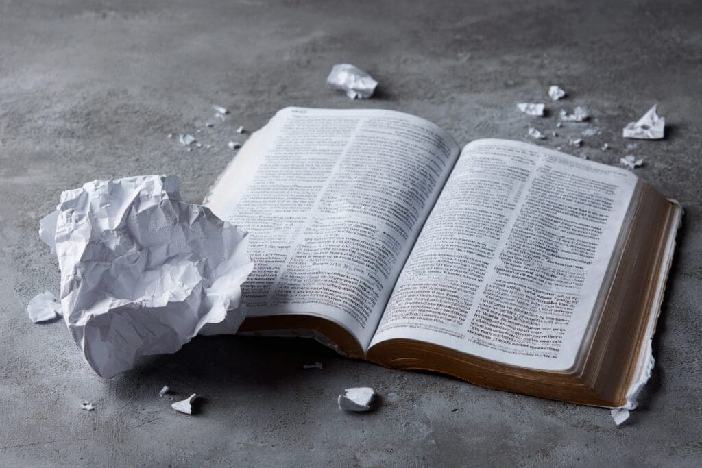 A crumpled page next to a Bible a warning for the FAQ on how not to read the Bible