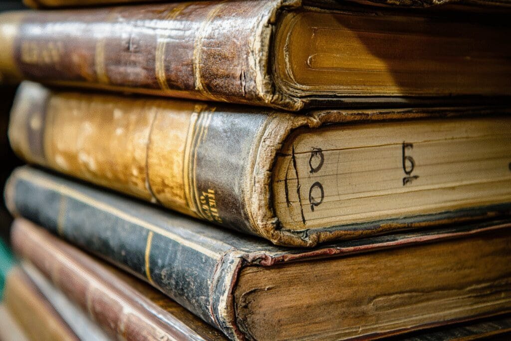 A stack of Bible books with the top five visibly thicker and marked with numbers, representing the longest books
