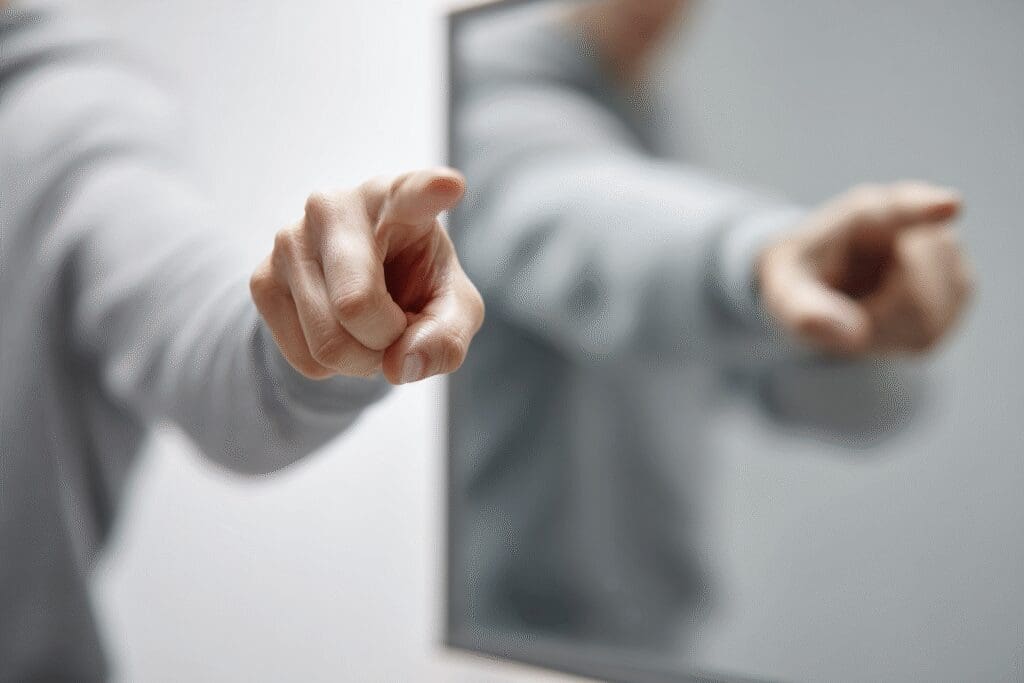 A person pointing a finger while their reflection points back a metaphor for the FAQ can we judge others according to the Bible