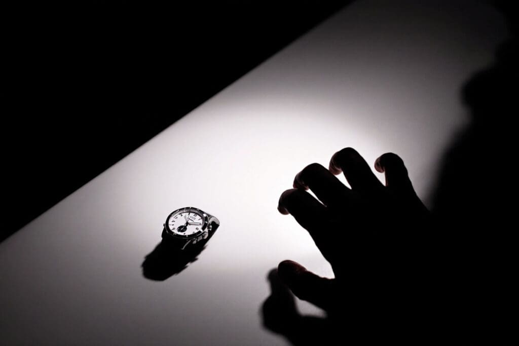 a shadowed hand reaching for a desired object in dim light representing the temptation and act of theft relating to what the bible says about theft